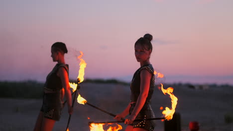 A-group-of-professional-circus-performers-with-fire-shows-dance-shows-in-slow-motion-using-flame-throwers-and-rotating-the-torches-burning-objects